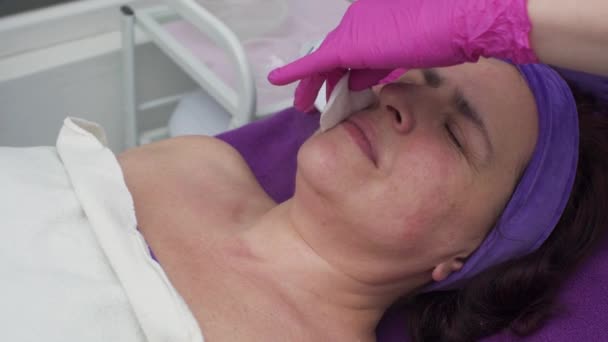 The beautician performs cavitation peeling of the cheeks using an ultrasound device. Close Up View. — Stock Video