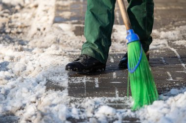 Bir işçi kaldırımları kardan temizlerken yakın çekim görüntüsü