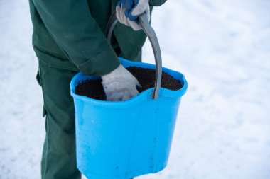 Bir el işçisinin mavi kovayla gidip kaldırımlara genişletilmiş kil serptiğini görebilirsiniz. Böylece kış mevsiminde kaygan olmazlar.