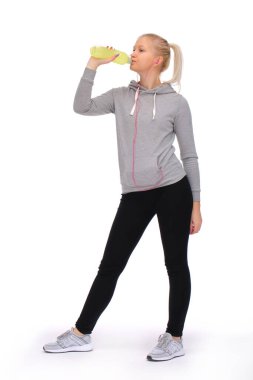 Yoğun egzersiz sırasında, kız enerji içeceği içerek zaman geçirir.