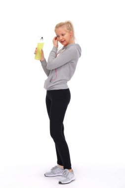 Jimnastik egzersizlerinden önce, genç kız kulaklıklarını ayarlayacak ve elinde bir enerji içeceği tutacak.