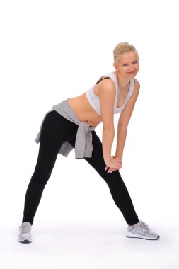 Kız egzersiz yapıyor, yerde sürünürken derin kıvrımlar yapıyor.