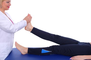 Bir fizyoterapist, nabız baskısı uygulayarak ayağın üst kısmındaki kaslara rahatlatıcı bir masaj yapar.