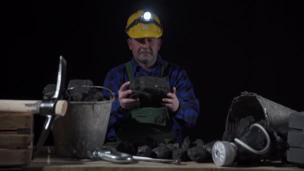 Ένας ανθρακωρύχος μετατρέπει ένα μεγάλο κομμάτι μαύρου άνθρακα στα χέρια του — Αρχείο Βίντεο