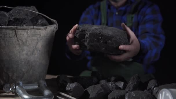 Eine Nahaufnahme zeigt, wie die Hände der Bergleute einen Klumpen schwarzer Kohle drehen — Stockvideo