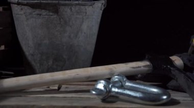 Ahşap platformda içinde kömür olan bir kova, filtresi olan koruyucu bir maske ve parlayan bir el feneri olan bir miğfer görebilirsiniz.