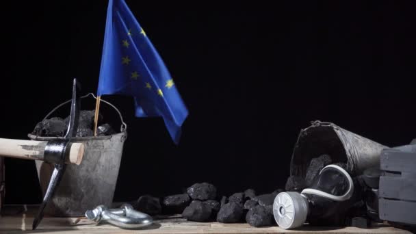 Uma bandeira da União Europeia é colocada num balde de carvão negro e agitada ao vento — Vídeo de Stock