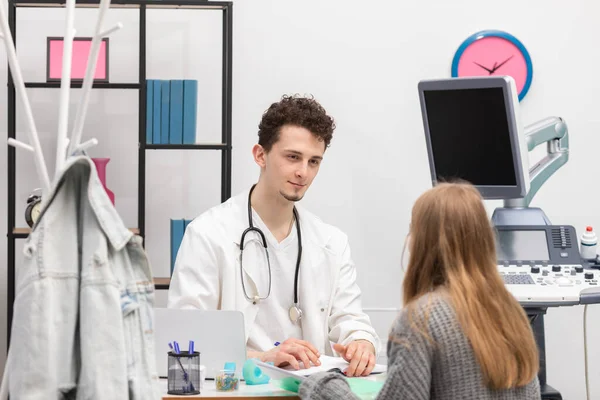 Un médico está hablando con un paciente en el consultorio de su médico. Una adolescente enferma se sienta en el consultorio de su médico. Ultrasonido gráfico —  Fotos de Stock