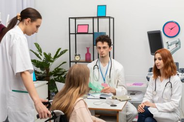 Bir hemşire tekerlekli sandalyeyle bir genci doktor odasına getirdi. Genç, test sonuçlarını doktora verir.