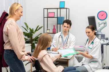 Anne, tekerlekli sandalyedeki genci doktor odasına getirdi. Genç, test sonuçlarını hemşireye verir.