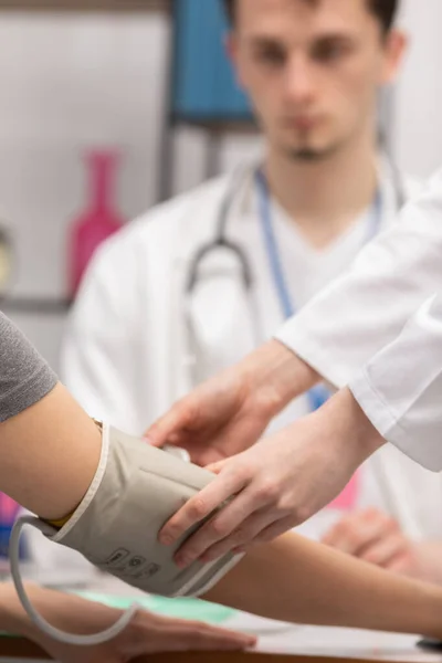 Bir hemşirenin hastanın koluna tansiyon monitörü yerleştirdiği yakın çekim görüntüsü. Pratisyen hekim. Doktorun ofisi. — Stok fotoğraf