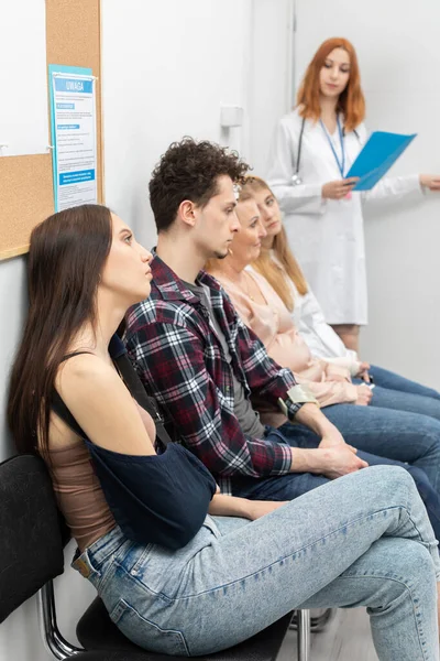 O médico deixa o consultório e, de acordo com a lista, pede o próximo paciente na fila. Imagem de close-up — Fotografia de Stock