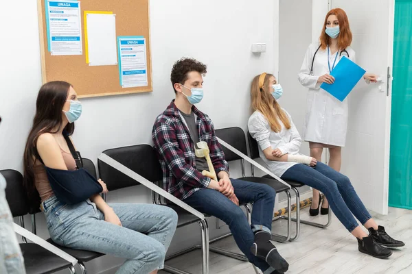 Doktor sıradakini yüksek sesle okur. Salgın sırasında herkes koruyucu maske takmak zorundadır. — Stok fotoğraf