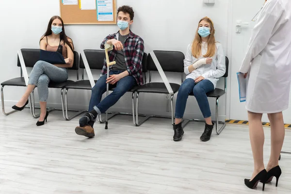 O médico lê a próxima pessoa na fila. Durante uma pandemia todos devem usar máscaras protetoras — Fotografia de Stock