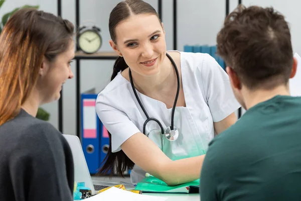 Egy nőgyógyász meglepő eredményt mutat egy tesztről, egy terhes betegről. Egy házaspár a nőgyógyásznál.. — Stock Fotó