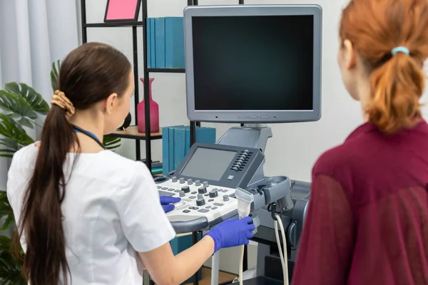 El médico se encarga de la ecografía mientras la paciente espera a que se realice el examen mamario.. — Foto de Stock