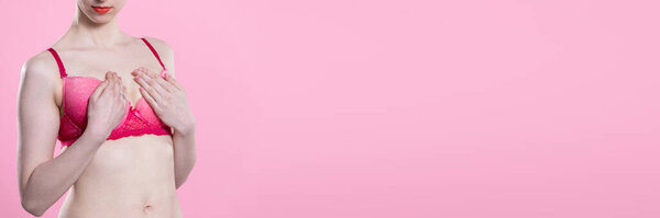 A woman performs a breast self-examination and checks for hard areas or lumps. Close-up view. Panoramic frame.