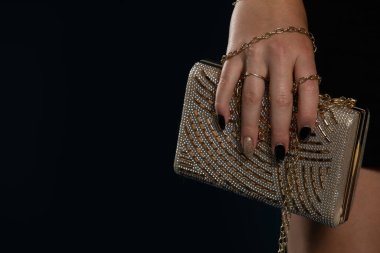 Bayanlar için altın bir çanta narin bayanlar için lacivert arka planda.