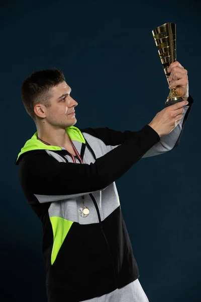 Ein Athlet mit einer Trophäe in der Hand für den ersten Platz bei einer Veranstaltung. — Stockfoto