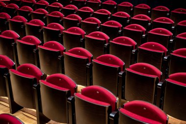 Muhteşem ve nefes kesici boş kırmızı kadife tiyatro koltukları mükemmel bir şekilde dizilmiş.