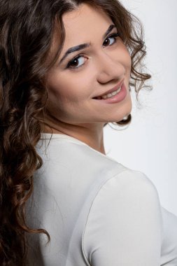 Kıvırcık saçlı, kendine güveni, güzelliği ve cazibesi olan genç bir kadının büyüleyici portresi.