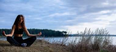 Huzurlu göl kenarında derin bir meditasyon anı. Doğayla ve iç huzurla derin bir bağ kuruyor.