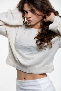 Bir manken zarif bir şekilde şık bir süveter ve bol pantolonla rahat bir kış görüntüsü sergiler.