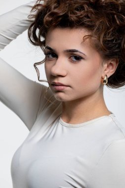 Şehvetli kıvırcık saçlı ve inkar edilemez bir stil anlayışı olan kendine güvenen bir kadının büyüleyici portresi.