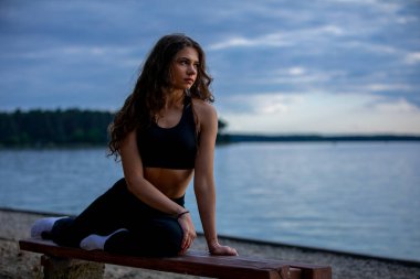 Huzurlu ve huzurlu bir yoga anı. Alacakaranlıkta sakin gölün kenarında. Güzelce sağlık ve zindelik göstergesi.