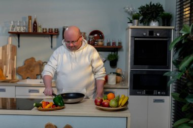 Yetenekli bir şef şık bir mutfak ortamında taze sebze ve meyve kullanarak lezzetli yemekler hazırlar.