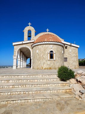 Kırmızı kubbeli taş bir kilise mavi gökyüzüne karşı duruyor, huzurlu manzaralar ve mutlu anlar için mükemmel.