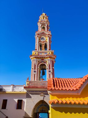 Güneşle aydınlatılan göz kamaştırıcı bir kilise kulesi berrak mavi gökyüzüne karşı canlı bir mimari sergiliyor.