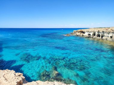 A breathtaking coastal scene showcasing vibrant turquoise waters alongside rocky shorelines filled with beauty