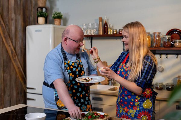 Два человека, наслаждаясь и оценивая их домашнее блюдо вместе, пара лиц отбор проб и анализ самостоятельно приготовленные блюда в уютной кухне