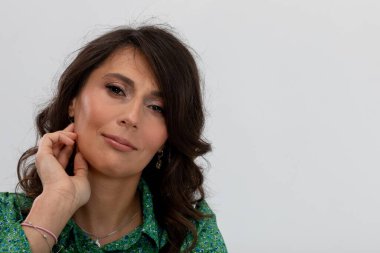 Küpelerini, derin düşüncelere dalmış, kıvırcık saçlı, ince takılar, özgüven, stüdyo ışıklandırması, yaratıcı profesyonel...