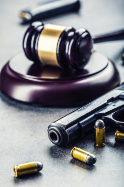 Judge's hammer gavel. Justice and gun. Justice and the judiciary in the unlawful use of of weapons. Judgment in murder