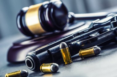 Judge's hammer gavel. Justice and gun. Justice and the judiciary in the unlawful use of of weapons. Judgment in murder