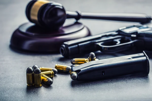 Judge's hammer gavel. Justice and gun. Justice and the judiciary in the unlawful use of of weapons. Judgment in murder — Stockfoto