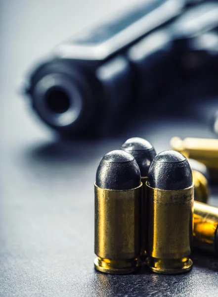 Пистолет калибра 9 мм и пули, разбросанные на столе — стоковое фото