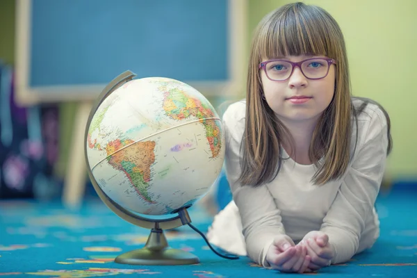 Pretty little student girl studying geography with globe in a child's room — Stok fotoğraf