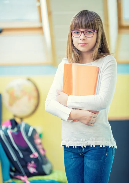 Молодая красивая доподростковая девочка с буклетом. Ребенок делает домашнее задание — стоковое фото
