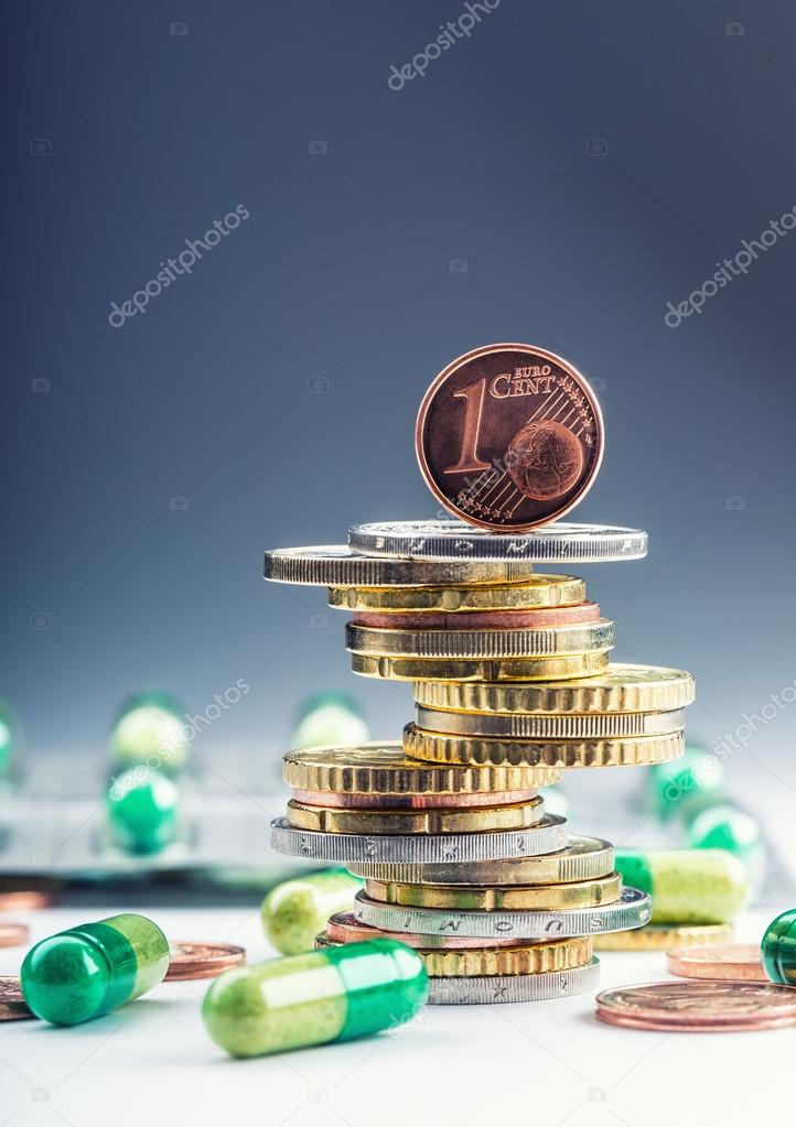 Euro money and medicaments. Eurocoins and pills. Coins stacked on each other in different positions and freely pills scattered around. Reimbursement of medicinal products in health care