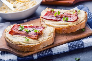 Spreads. Egg spread, grilled bacon, bread young basil leaves, Herb decoration. Ingredients: six eggs, spring onion, yeast, processed cheese, bacon, salt, pepper, various herbs decorations