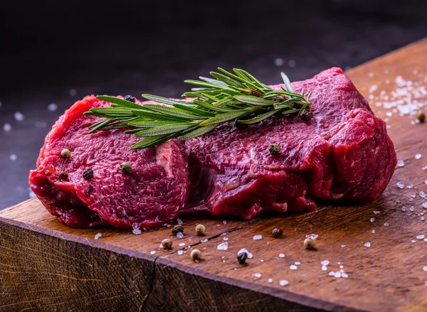 Bistecca. Bistecca di manzo cruda. Carne fresca cruda di manzo Sirloin affettato o Herb - Decorazione al rosmarino — Foto Stock