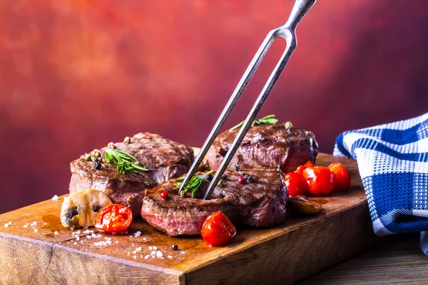 Grill beef steak. Portions thick beef juicy sirloin steaks on grill teflon pan or old wooden board — Stock Photo, Image