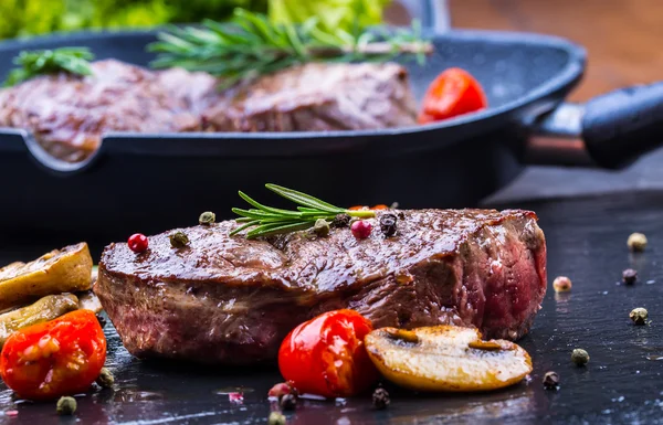 Griller le steak de bœuf. Portions steaks de surlonge juteux de bœuf épais sur le gril poêle en téflon ou vieille planche en bois — Photo