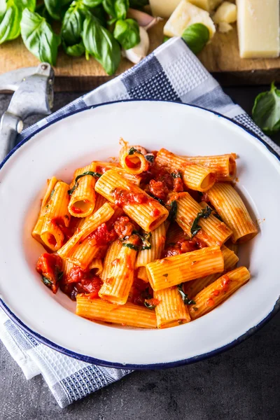 Pasta. Cocina italiana y mediterránea. Pasta Rigatoni con salsa de tomate hojas de albahaca ajo y queso parmesano. Una cocina casera antigua con utensilios de cocina antiguos —  Fotos de Stock