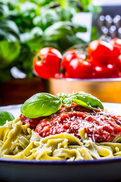 Pasta. Cocina italiana y mediterránea. Pasta Fettuccine con salsa de tomate hojas de albahaca ajo y queso parmesano. Una antigua cocina casera con utensilios de cocina antiguos. Porción de en un tenedor pasta con salsa de tomate y hojas de albahaca — Foto de Stock