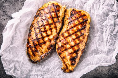 Çeri domatesli, mantarlı, otlu farklı çeşitlerde ızgara tavuk göğsü, ahşap bir tahtada limon kesimi veya teflon tavası. Geleneksel mutfak. Izgara mutfağı