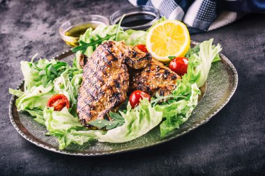 Farklı çeşitlerde ızgara tavuk göğsü, marul salatası, kiraz mantarı, otlar, tahtadan yapılmış limon dilimleri ya da teflon tavası. Geleneksel mutfak. Izgara mutfağı